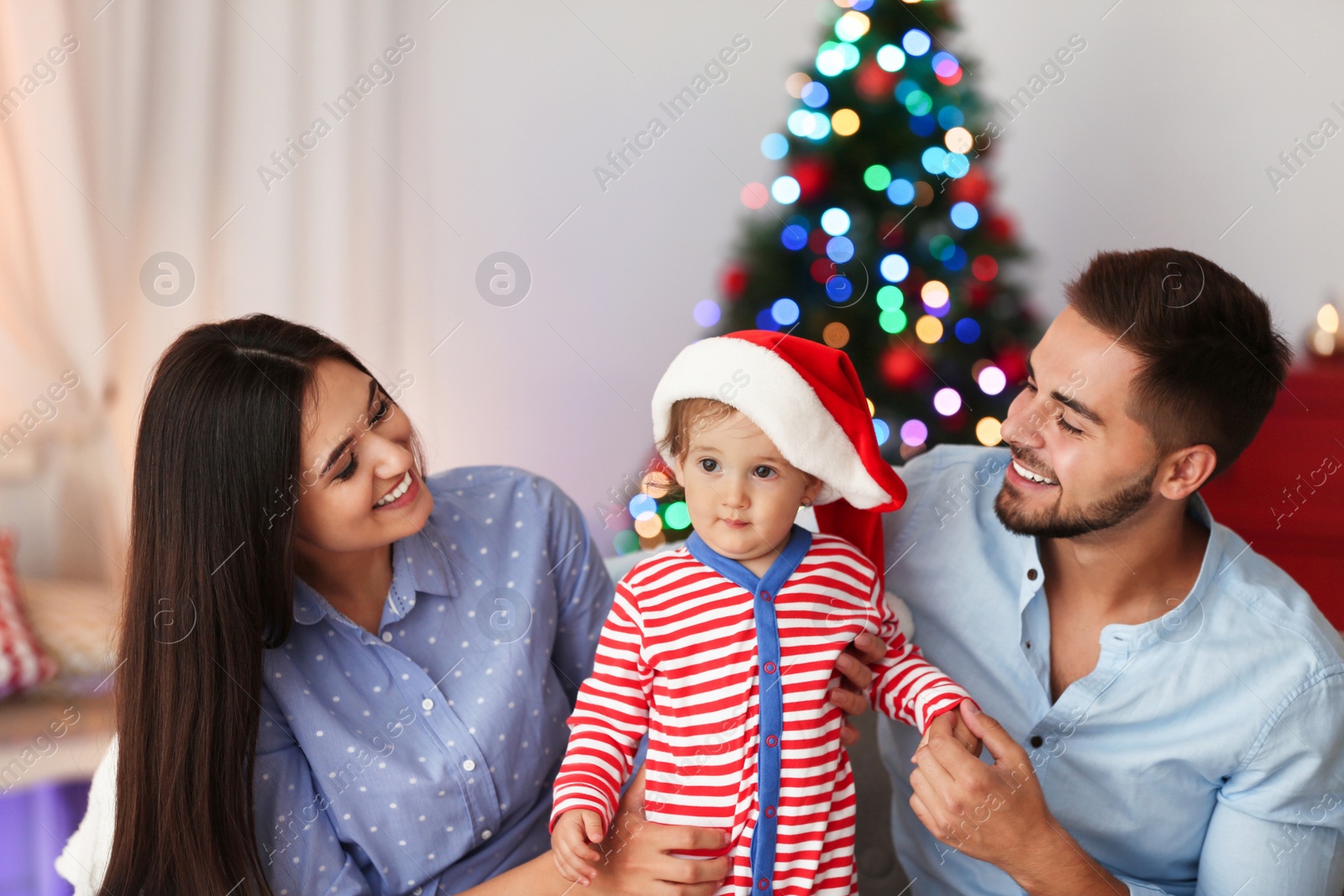 Photo of Happy family with cute baby at home. Christmas celebration