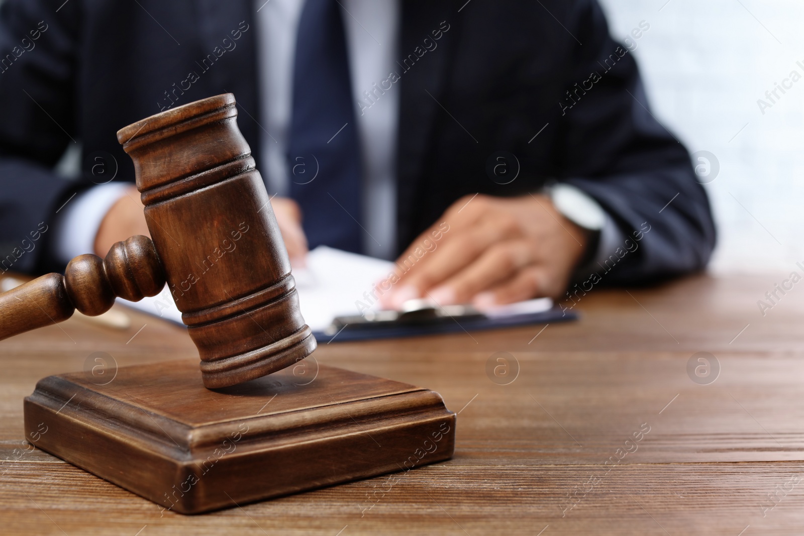 Photo of Wooden gavel and blurred lawyer on background. Notary services