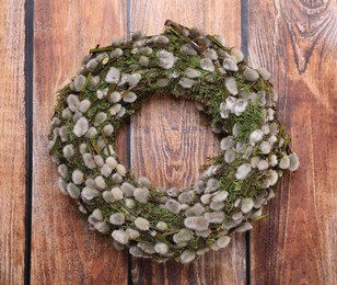 Photo of Wreath made of beautiful willow flowers on wooden table, top view