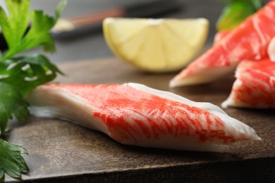 Photo of Cut crab sticks on wooden board, closeup