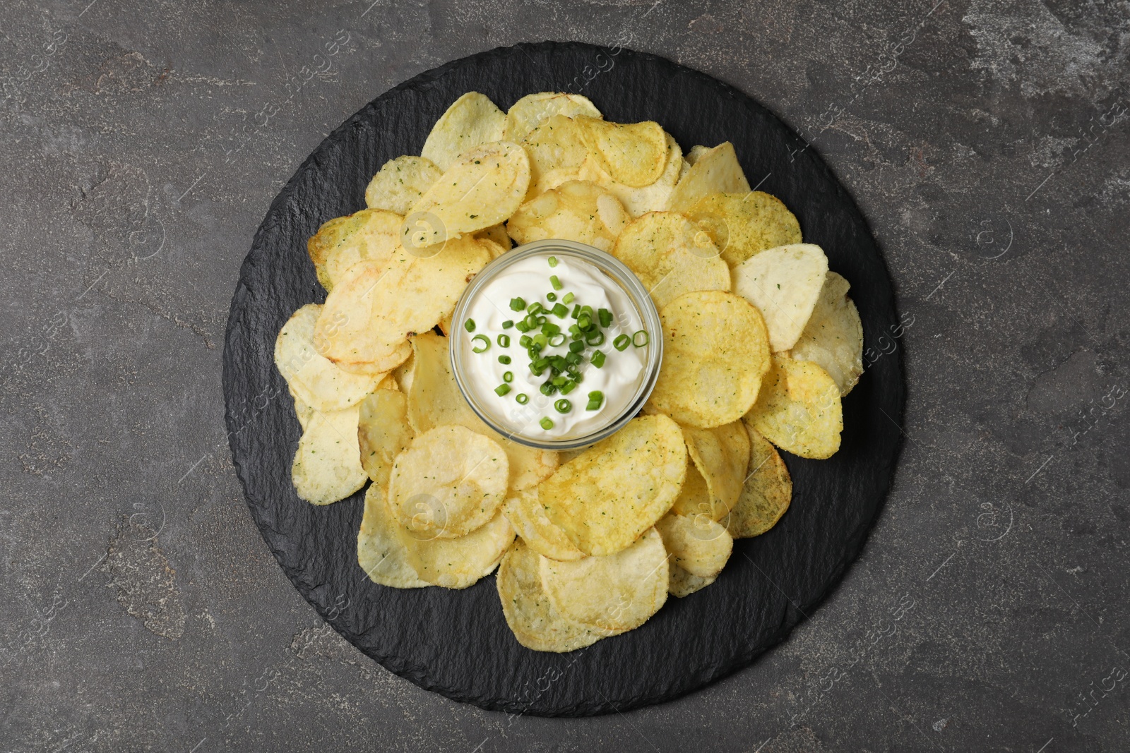 Photo of Chips with sour cream on grey table, top view