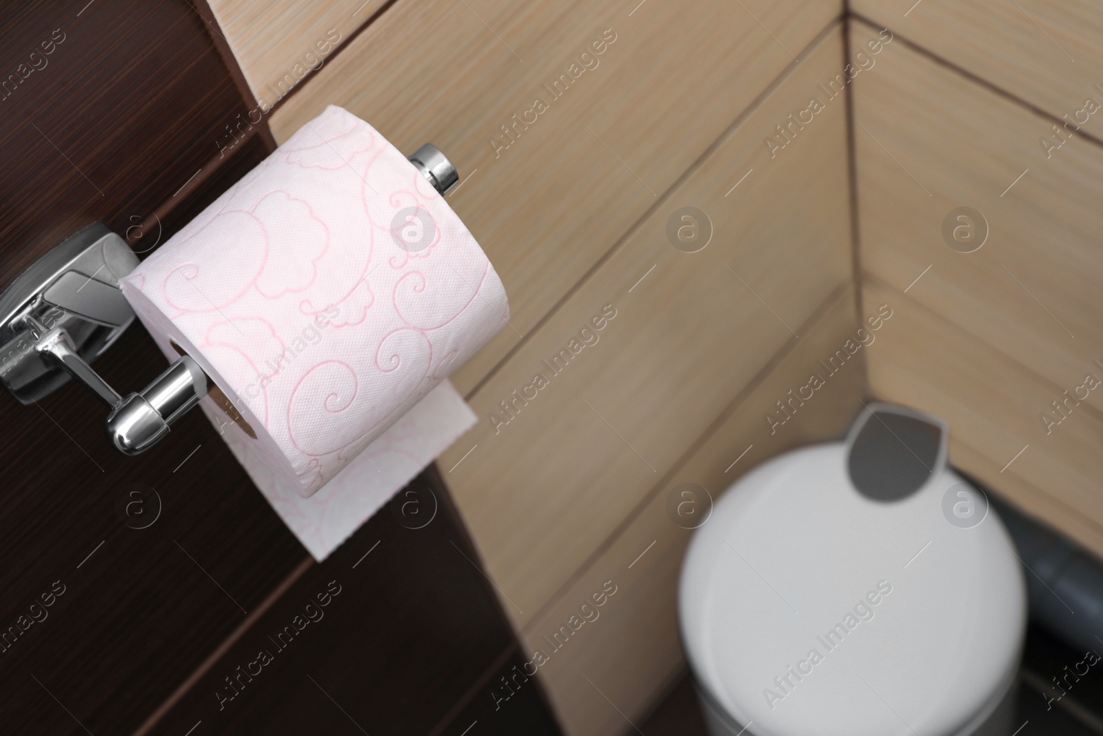 Photo of Holder with soft toilet paper roll in bathroom. Space for text