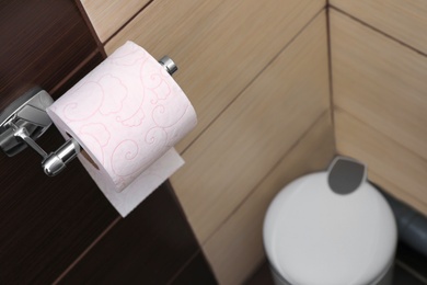 Photo of Holder with soft toilet paper roll in bathroom. Space for text