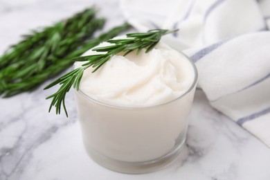 Photo of Delicious pork lard with rosemary in glass on white marble table, closeup