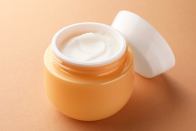 Photo of Jar of face cream on beige background, closeup
