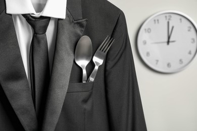 Photo of Cutlery in breast pocket of men`s jacket indoors, closeup. Business lunch concept