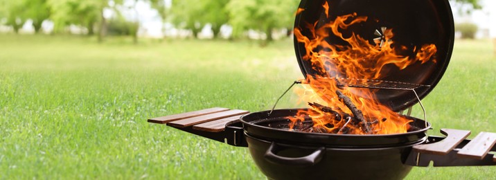 Image of Modern barbecue grill with fire flames outdoors, space for text. Banner design