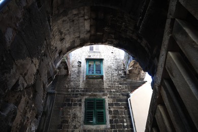 Photo of Old residential building, low angle view through arch entrance