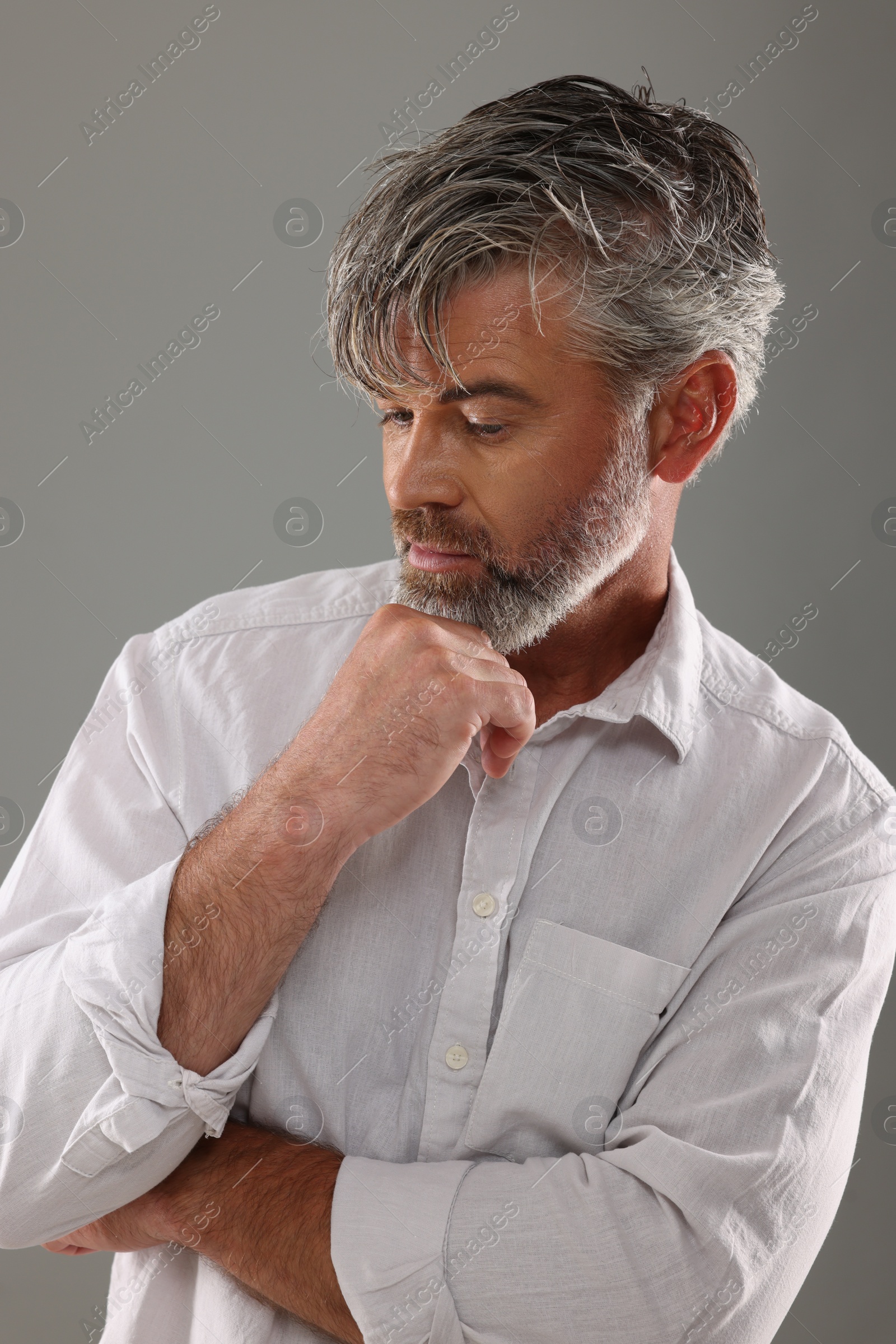 Photo of Portrait of confident man with beautiful hairstyle on light grey background