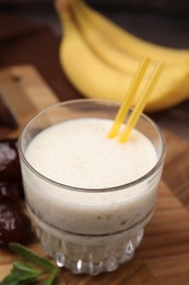 Photo of Glass of delicious date smoothie on board, closeup