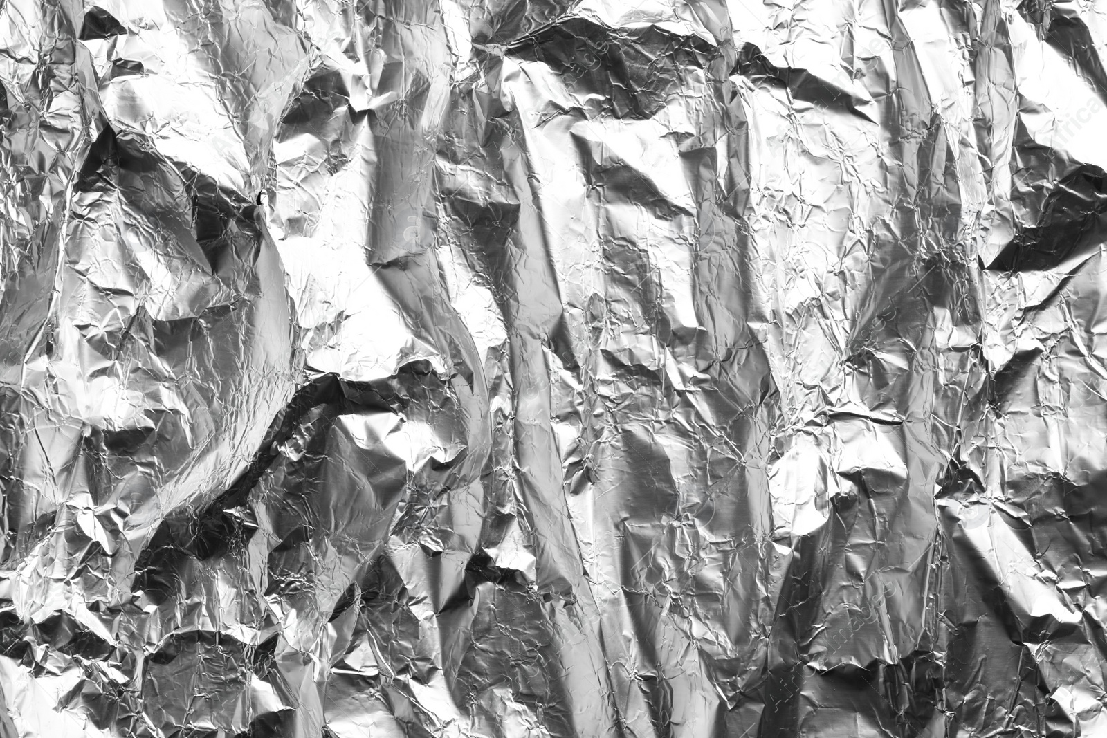 Photo of Crumpled silver foil as background, closeup view