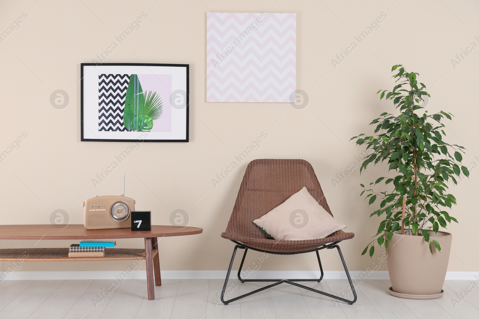 Photo of Stylish living room interior with armchair and houseplant near beige wall