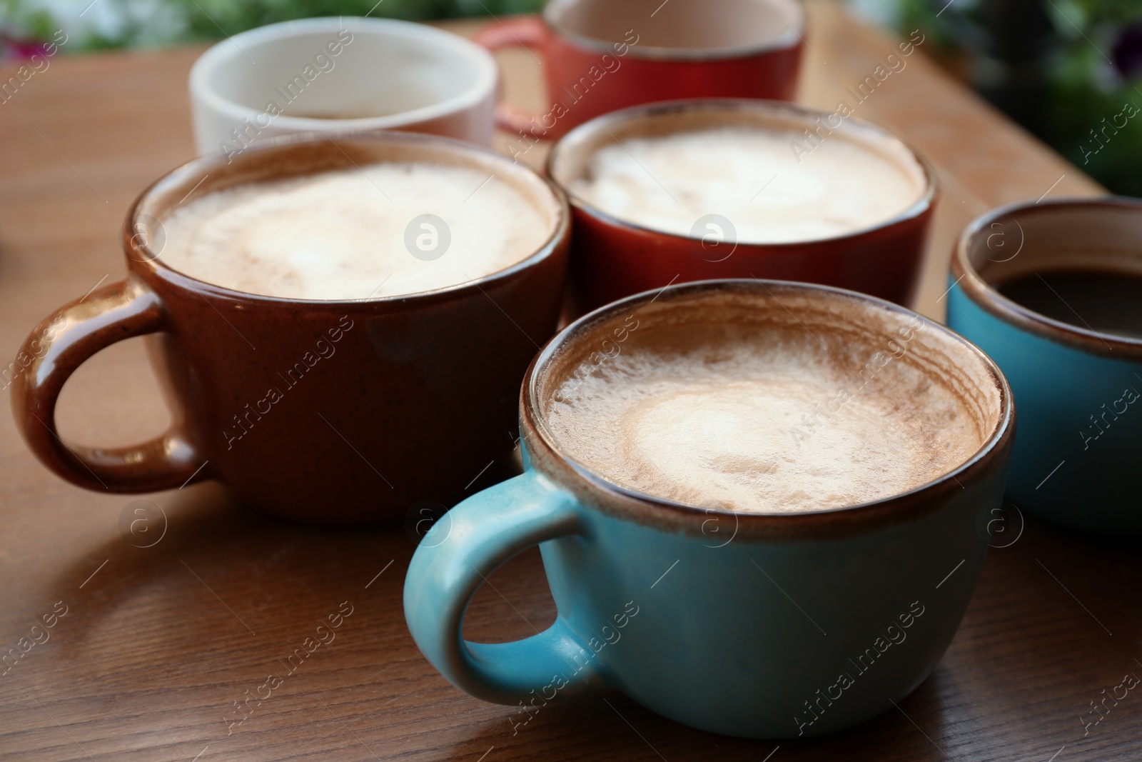 Photo of Cups of fresh aromatic coffee on wooden table