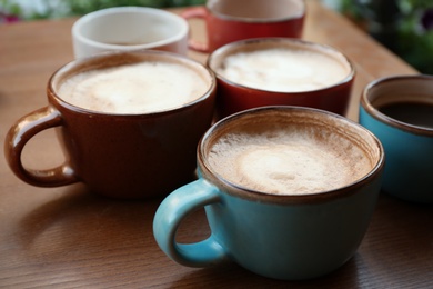 Cups of fresh aromatic coffee on wooden table