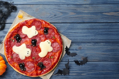 Photo of Cute Halloween pizza with ghosts and spiders served on blue wooden table, flat lay. Space for text