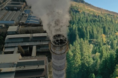 Environmental pollution. Collage divided with smoke into mountain landscape and industrial factory