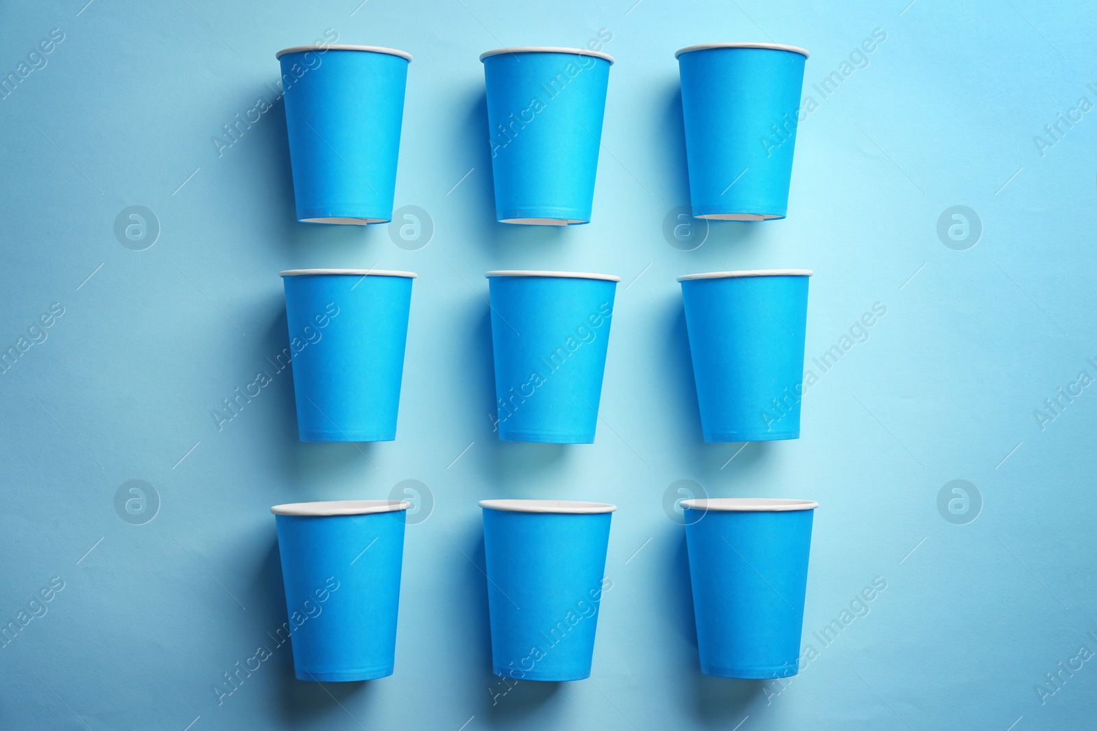 Photo of Flat lay composition with plastic cups on color background. Table setting