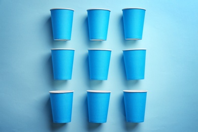 Photo of Flat lay composition with plastic cups on color background. Table setting