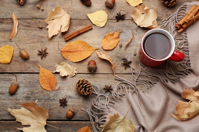 Photo of Flat lay composition with cup of hot drink on wooden table. Cozy autumn atmosphere