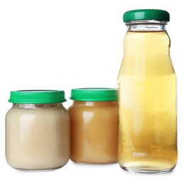 Baby food in jars near bottle of juice on white background