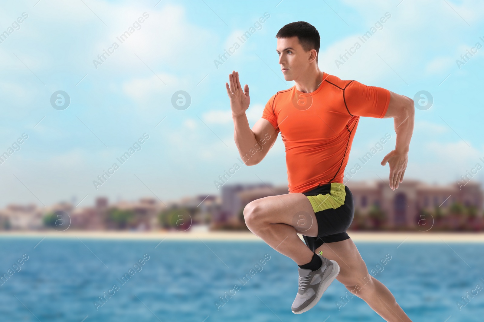 Image of Athletic young man running near sea on sunny day, space for text 