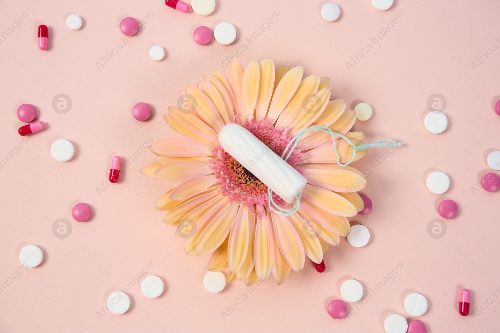 Photo of Flat lay composition with flower, pills and tampon on color background. Gynecological checkup