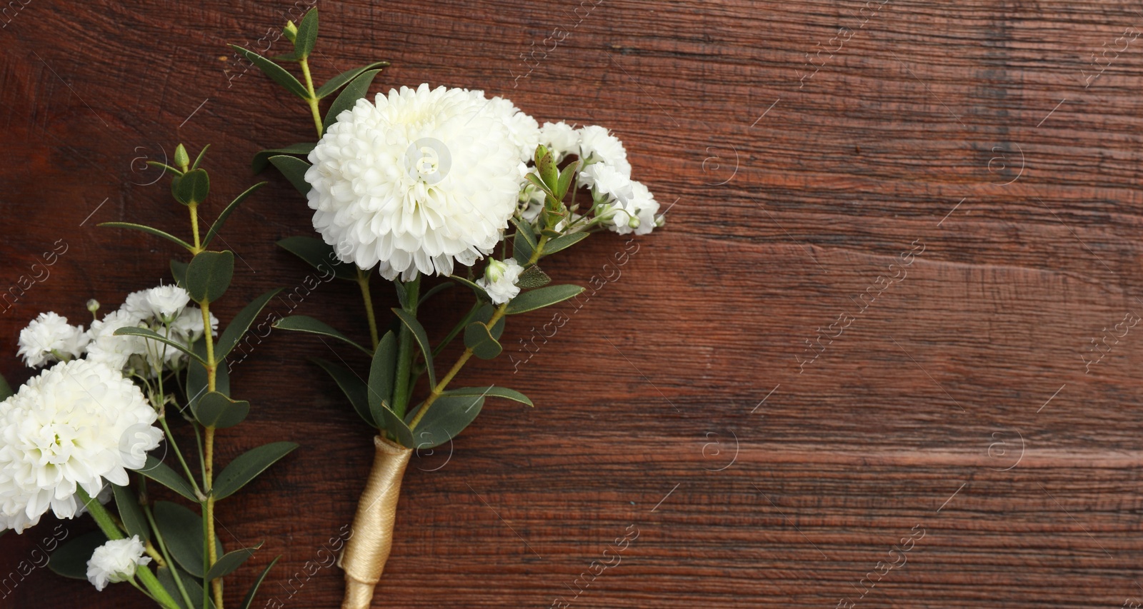 Photo of Small stylish boutonnieres on wooden table, top view. Space for text