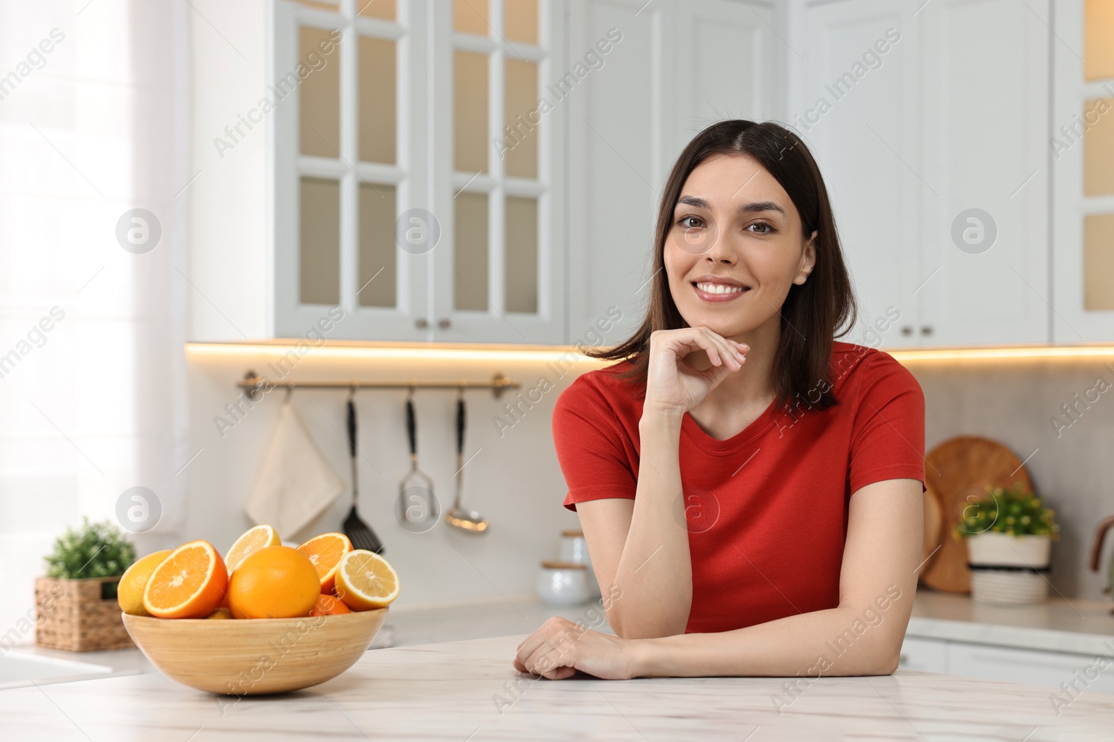 Photo of Portrait of beautiful young woman in kitchen