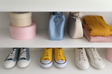 Photo of White shelving unit with collection of colorful sneakers and accessories