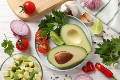 Photo of Fresh ingredients for guacamole on white wooden table, flat lay