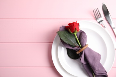 Photo of Romantic table setting on pink wooden background, flat lay with space for text. Valentine's day celebration