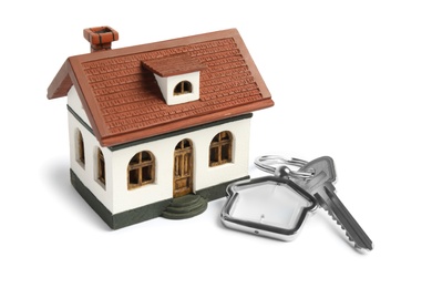 Photo of Key with trinket and house model on white background