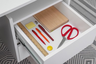 Office supplies in open desk drawer indoors