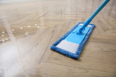 Washing of parquet floor with mop, closeup. Space for text