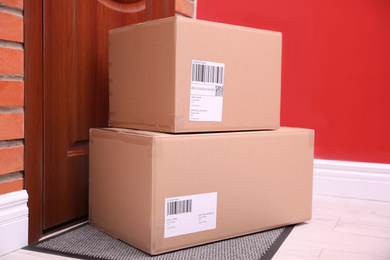 Photo of Parcels on rug near door. Delivery service