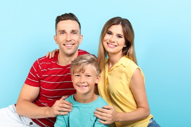 Little boy with mother and father on color background