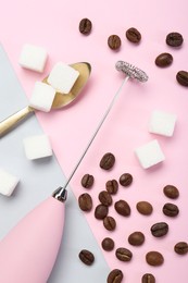 Pink milk frother wand, coffee beans and sugar cubes on color background, flat lay