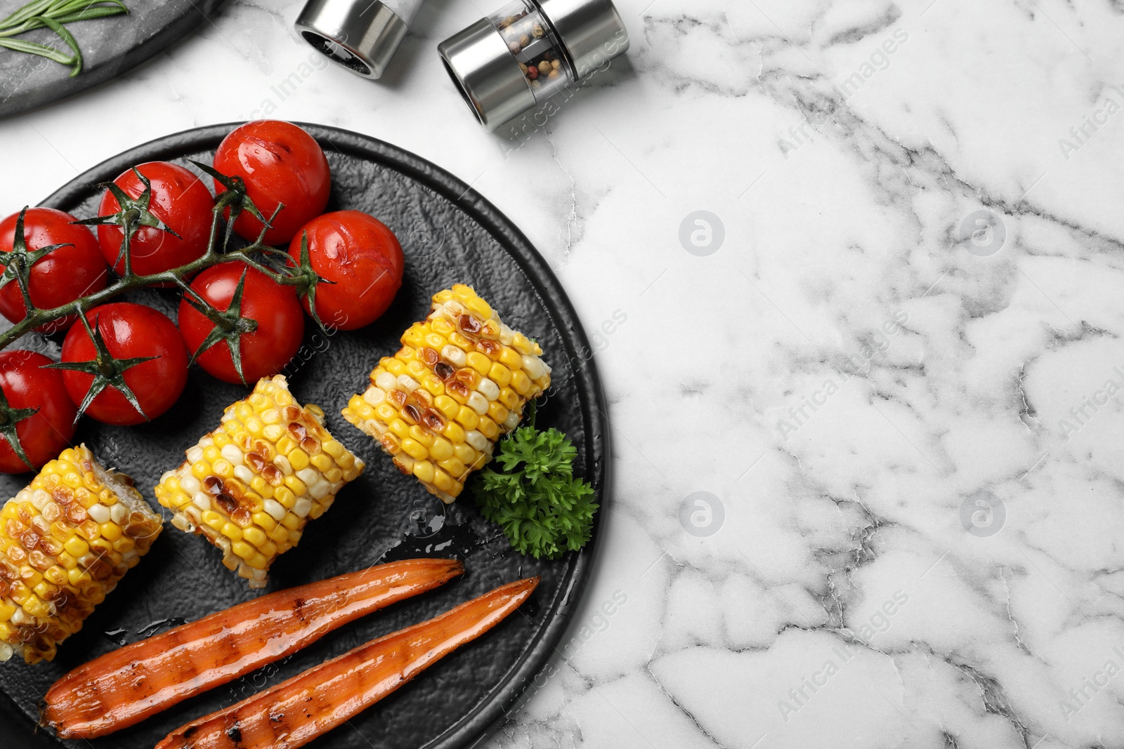 Photo of Delicious grilled vegetables served on white marble table, flat lay. Space for text
