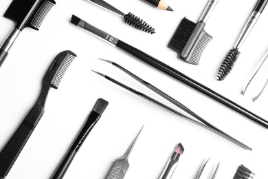 Photo of Set of professional eyebrow tools on white background, top view