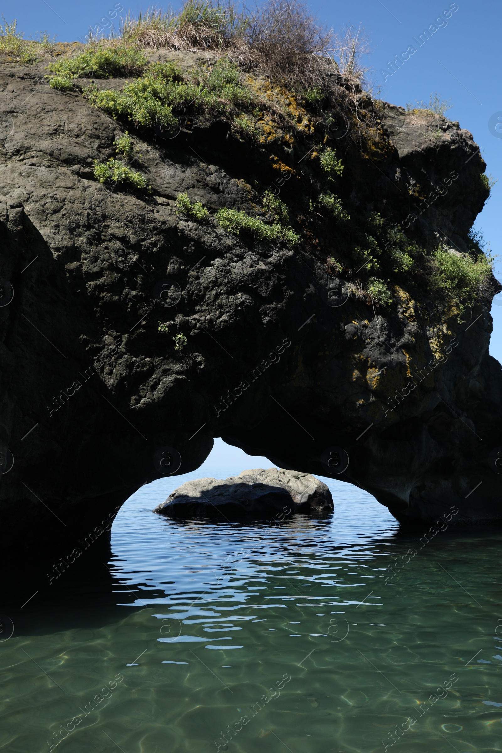 Photo of Picturesque view of natural stone arch above sea. Rock formation