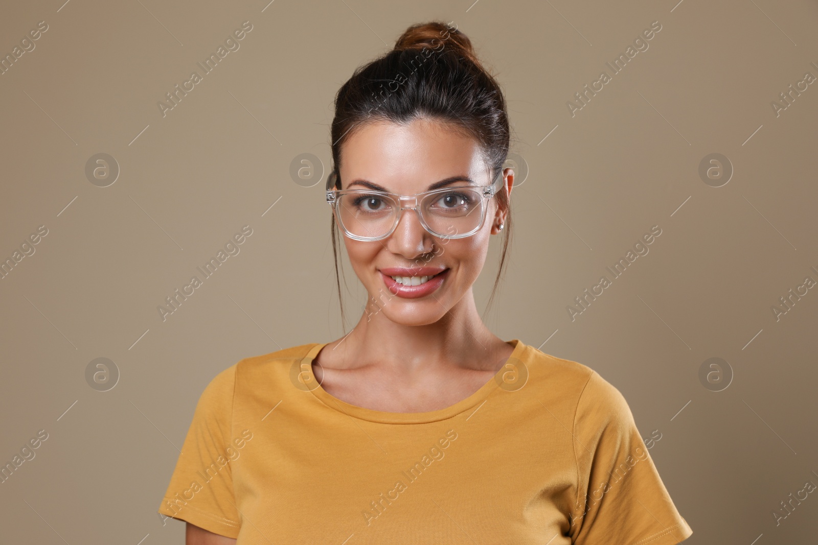 Photo of Beautiful woman in eyeglasses on beige background