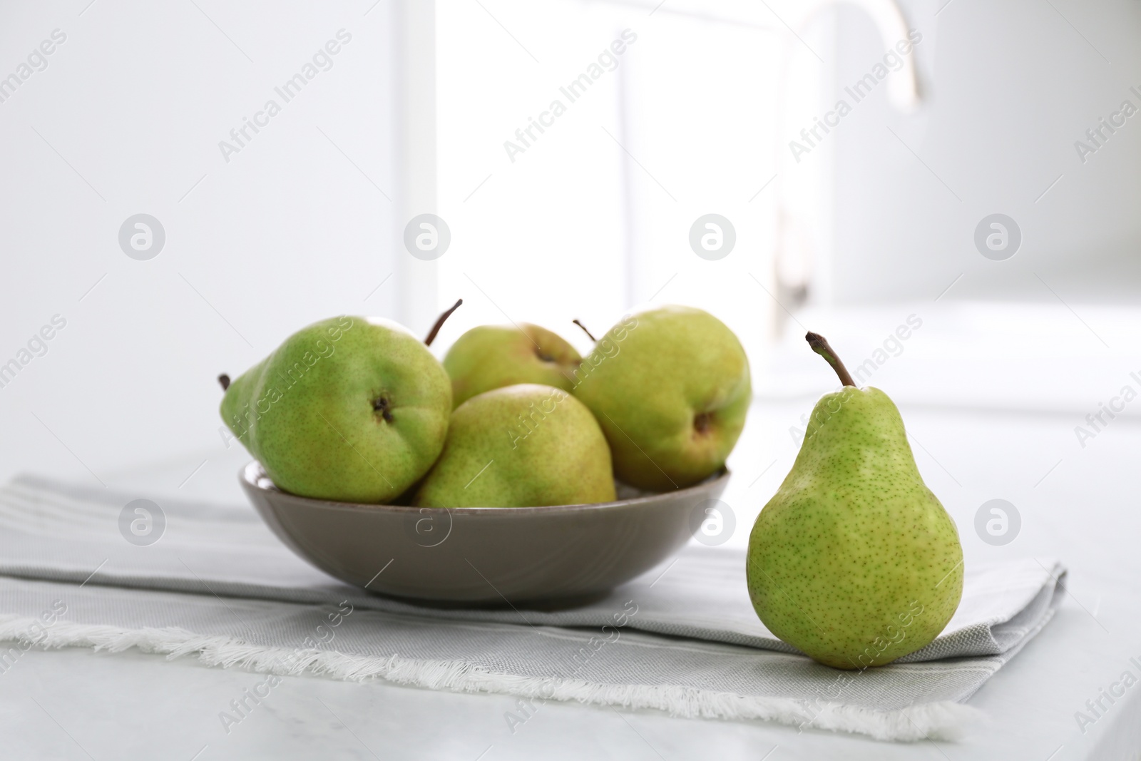 Photo of Fresh ripe pears on countertop in kitchen