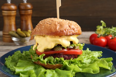 Photo of Delicious vegetarian burger and ingredients on table