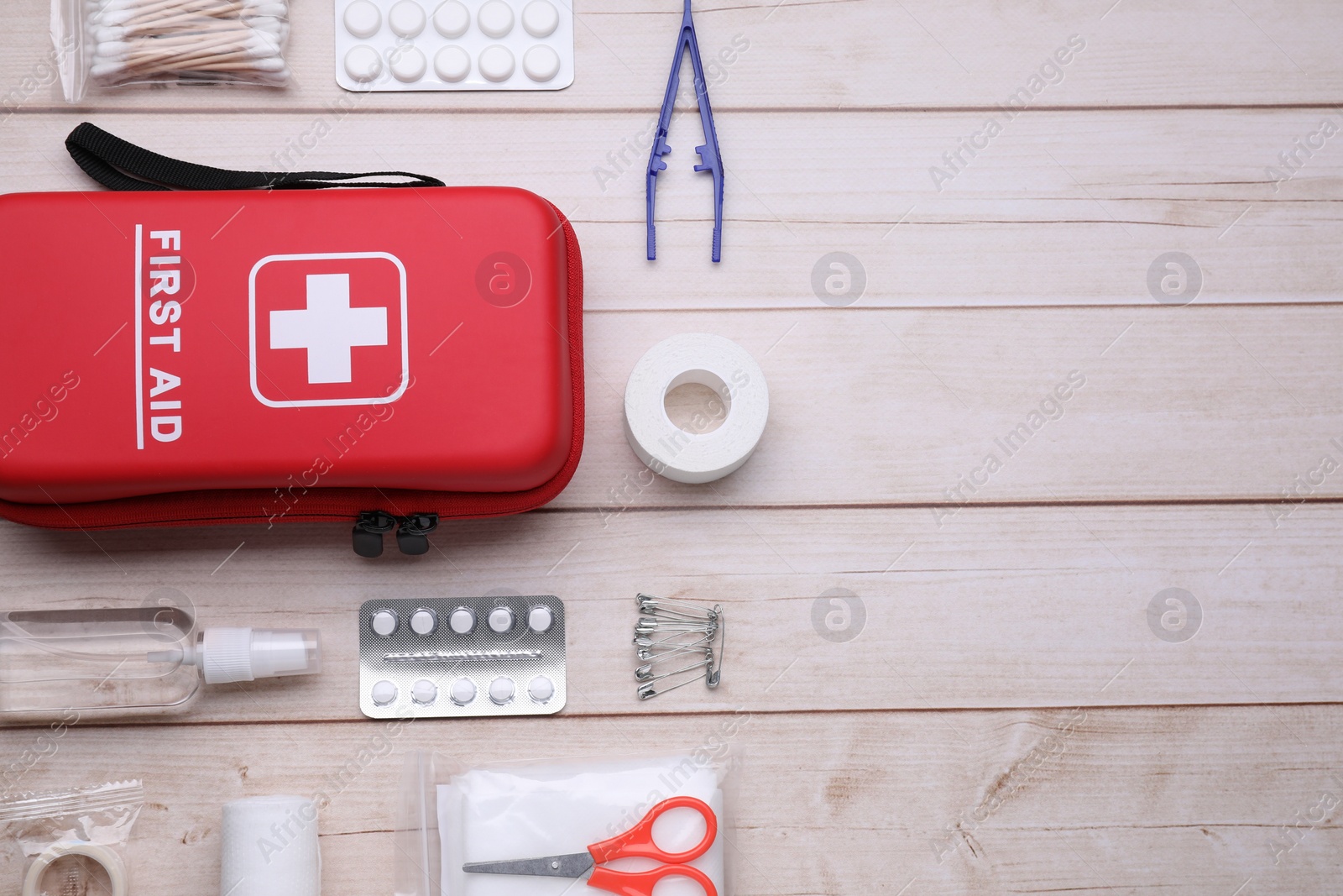 Photo of Flat lay composition with first aid kit on wooden table, space for text