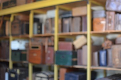 Blurred view of retro suitcases on shelves indoors