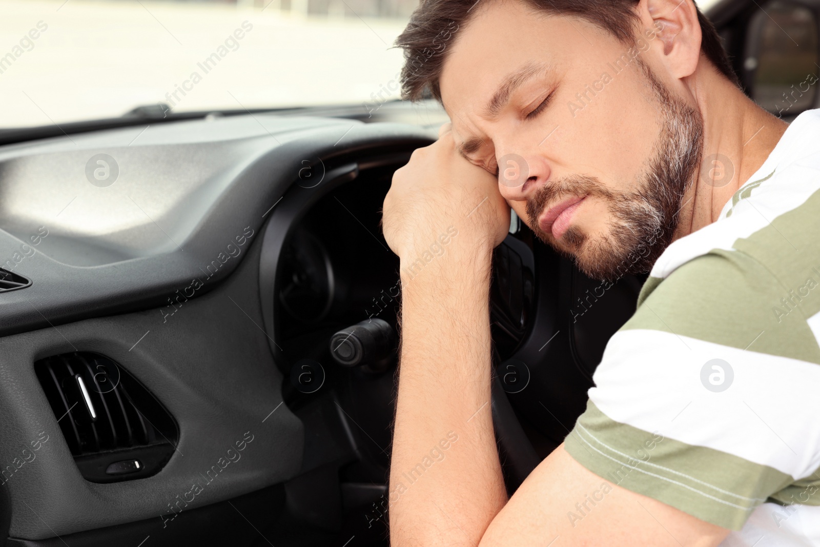 Photo of Tired man sleeping in his modern car, closeup