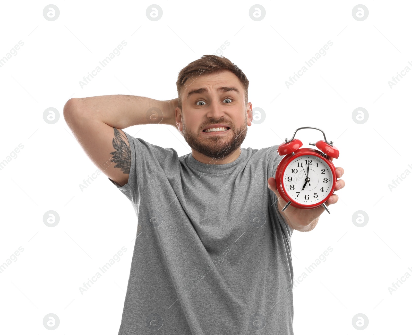 Photo of Emotional overslept man with alarm clock on white background. Being late concept