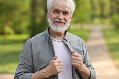 Photo of Portrait of happy grandpa in spring park