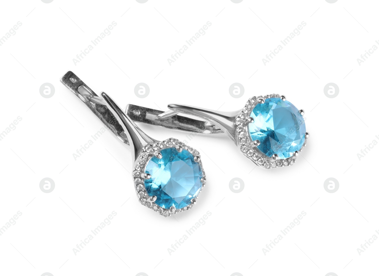 Photo of Elegant silver earrings with light blue gemstones isolated on white, top view. Luxury jewelry