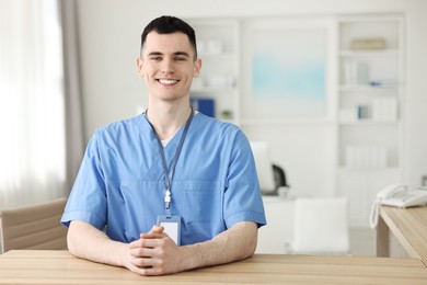 Photo of Smiling medical assistant at hospital reception. Space for text